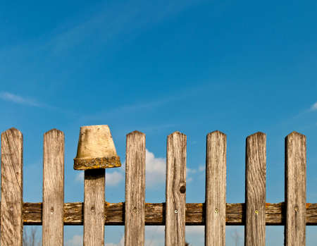 Vintage fence and a flower pot against a blue skyの写真素材