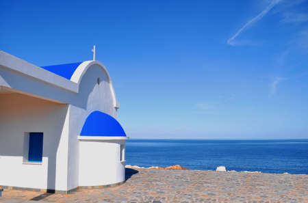 White chapel with blue roof on the beach in Cyprusの写真素材