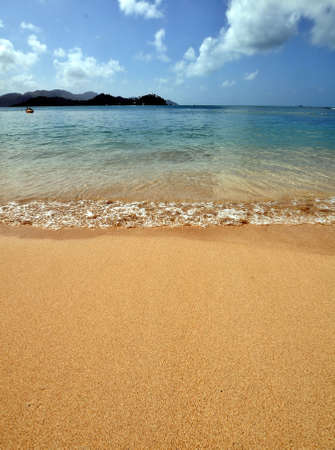 Sand and small waves on a beach in the caribbean sea