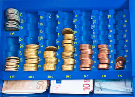 European money with coins and bills in a cash box