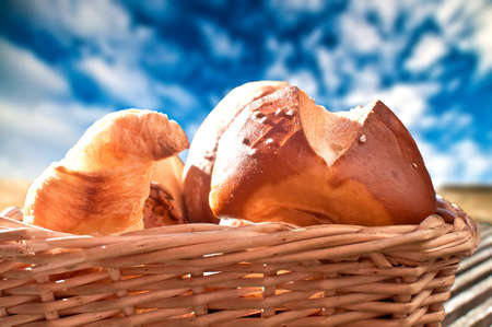 Croissant and roll in a wooden basketの写真素材