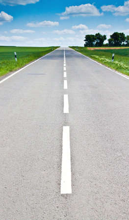 Vansihing road with middle line and bright sun