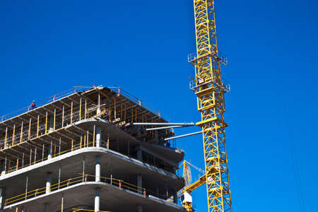 Construction of a skyscraper with a crane and blue skyの写真素材
