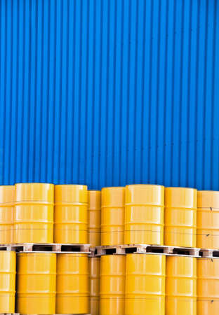 Yellow oil drums and a blue factory claddingの写真素材