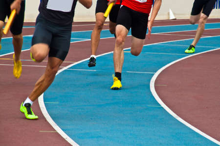 Runners on an athletic track during a relayの写真素材