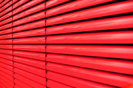 Vertical lines of a red shutter blindの写真素材