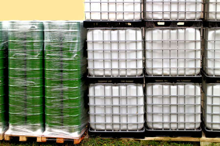 Green drums and white container on a chemical siteの写真素材