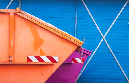 Orange and lilac container in front of a blue buildingの写真素材