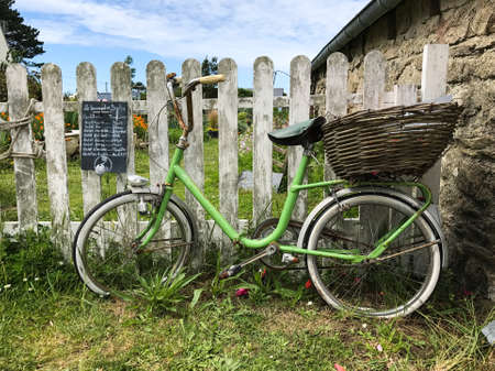 Old green bicycle on a vintage wooden garden doorの写真素材