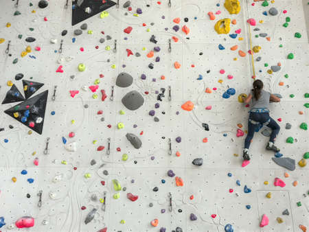 Girl climbing on a boulder wallの写真素材