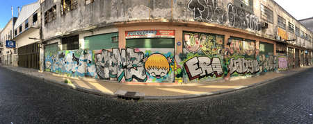 Old building with shutter and graffiti in a cobblestone roadのeditorial素材