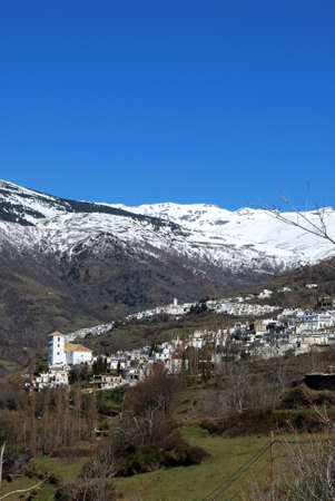 General view of town with Capileira to and snow capped mountains to rear, Bubion, Las Alpujarras, Granada Province, Andalusia, Spain, Western Europe の写真素材