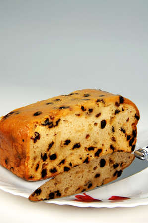 Sultana fruitcake on a white plate with a cake knife の写真素材