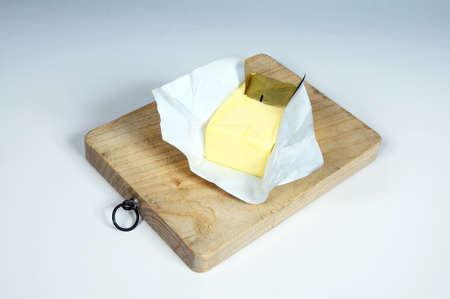 Block of English butter on a wooden chopping board の写真素材