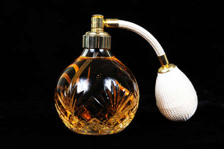 Cut glass perfume atomiser bottle against a black background の写真素材