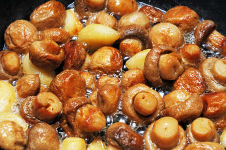 Whole button mushrooms and garlic cloves frying in butter, Costa del Sol, Malaga Province, Andalucia, Spain, Western Europe の写真素材