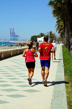 Malaga, Spain - June 14, 2011 - Joggers on the promenade alongside Malagueta beach, Malaga, Costa del Sol, Malaga Province, Andalucia, Spain, Western Europe のeditorial素材