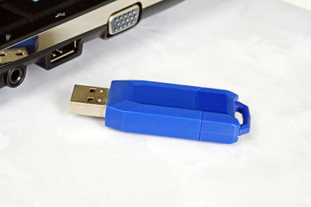 Blue USB stick sitting alongside a netbook