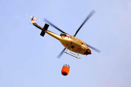 Cabopino, Spain - September 12, 2011 - Bell 412 helicopter  registration N167EH  carrying water for fire fighting, Cabopino Golf, Costa del Sol, Malaga Province, Andalucia, Spain, Western Europe  のeditorial素材