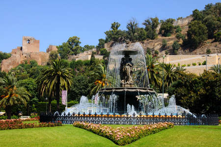 Malaga, Spain - June 14, 2011 - Fountain  Fuente de las tres gracias  at the end of Paseo del Parque with the castle  alcazaba  to rear, Malaga, Costa del Sol, Malaga Province, Andalucia, Spain, Western Europe のeditorial素材