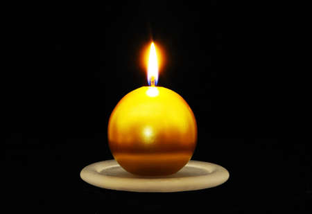 Round gold Christmas candle set against a black background の写真素材