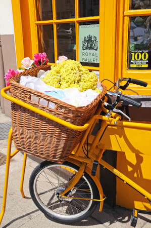 Stratford-upon-Avon, UK - May 18, 2014 - Bike with wicker basket full of flowers along Bridge Street, Stratford-Upon-Avon, Warwickshire, England, UK, Western Europe のeditorial素材