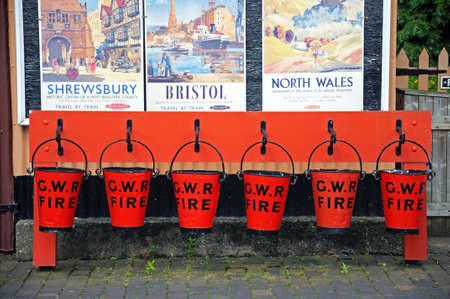Hampton Loade, United Kingdom - June 5, 2014 - Row of red Victorian Fire buckets on the railway platform, Hampton Loade, Shropshire, England, UK, Western Europe のeditorial素材