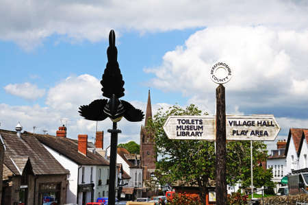 WEOBLEY, UNITED KINGDOM - JUNE 5, 2014 - View along Broad Street the magpie sculpture and fingerpost in the foreground and St Peter and St Paul church spire to the rear, Weobley, Herefordshire, England, UK, Western Europe のeditorial素材