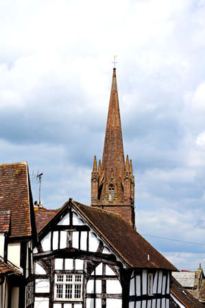 White timbered buildings with St Peter and St Paul church to the rear, Weobley, Herefordshire, England, UK, Western Europe の写真素材