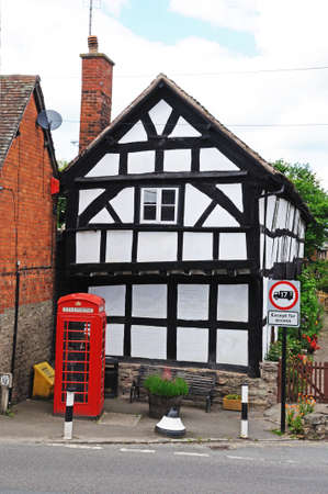 Traditional red phone box at the side of an old former white timber framed cottage hospital, Pembridge, Herefordshire, England, UK, Western Europe のeditorial素材