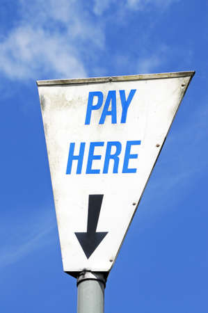 Pay here sign in a white triangle against a blue sky, Bourton on the Water, Gloucestershire, England, UK, Western Europe の写真素材