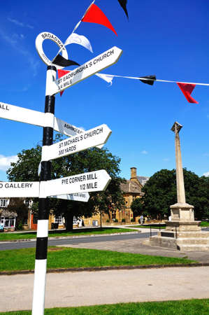 Broadway, UK - June 12, 2014 - Black and white signpost on the village green along the High Street giving directions to tourist attractions, Broadway, Cotswolds, Worcestershire, England, UK, Western Europe のeditorial素材