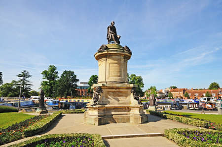 Stratford-upon-Avon, UK - June 12, 2014 - Statue of William Shakespeare sitting on top of the Gower Memorial with the Royal Shakespeare Theatre to the rear, Stratford-upon-Avon, Warwickshire, England, UK, Western Europe   のeditorial素材