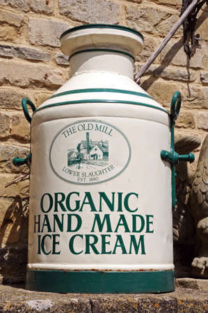 Lower Slaughter, UK - June 12, 2014 - Organic hand made ice cream painted onto an old milk churn outside the entrance to the Old Mill, Lower Slaughter, Cotswolds, Gloucestershire, England, UK, Western Europe のeditorial素材