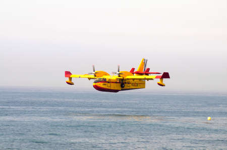 Calahonda, Spain - September 12, 2011 - Bombardier Canadair CL415 fire bomber  number 2064-4331  swooping down to collect seawater, Calahonda, Costa del Sol, Malaga Province, Andalucia, Spain, Western Europe  のeditorial素材