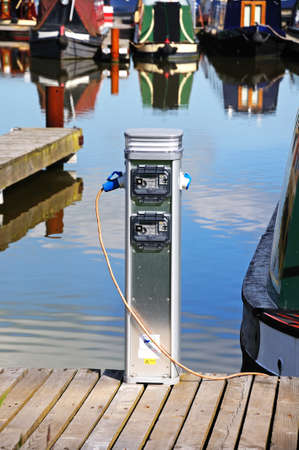 Barton-under-Needwood, UK - May 21, 2014 - Metered electricity supply unit on the jetty being used by a narrowboat in the canal basin, Barton Marina, Barton-under-Needwood, Staffordshire, England, UK, Western Europe のeditorial素材