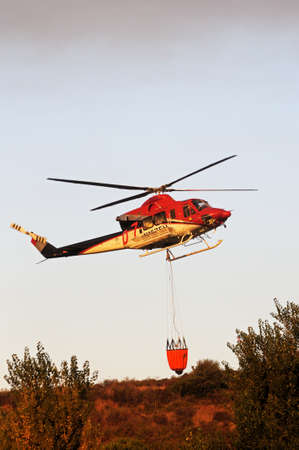 Cabopino, Spain - September 12, 2011 - Bell 412 helicopter (registration N167EH) collecting water for fire fighting from a golf course lake, Cabopino Golf, Costa del Sol, Malaga Province, Andalucia, Spain, Western Europe.のeditorial素材