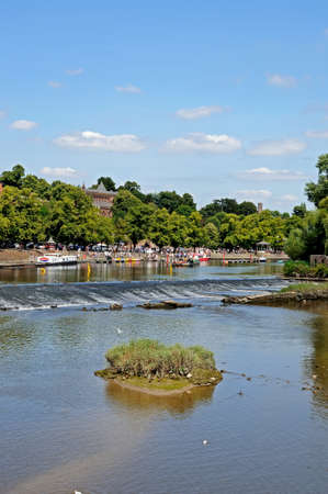 Chester, UK - July 22, 2014 - View of the weir along the River Dee with buildings to the rear, Chester, Cheshire, England, UK, Western Europe.のeditorial素材