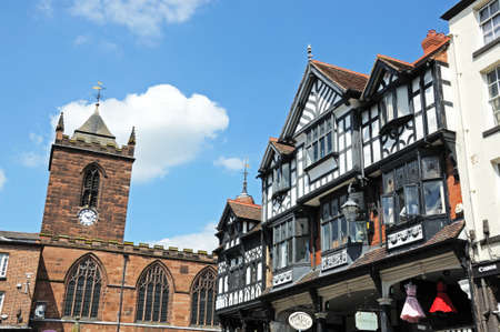 Chester, UK - July 22, 2014 - Buildings and shops along Bridge Street on the corner of Eastgate Street with St Peters church to the rear, Chester, Cheshire, England, UK, Western Europe.のeditorial素材
