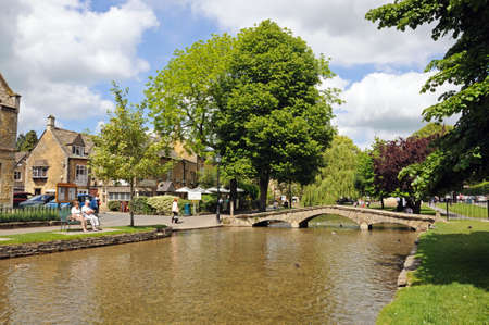 Bourton-on-the-Water, UK - June 12, 2014 - Stone footbridge across the River Windrush with tea-rooms to the rear, Bourton on the Water, Gloucestershire, England, UK, Western Europe.のeditorial素材