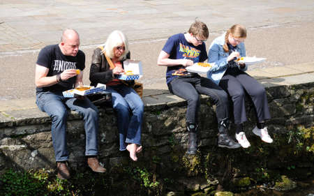 Bakewell, UK - September 7, 2014 - Family sitting on the riverbank eating fish and chips, Bakewell, Derbyshire, England, UK, Western Europe.のeditorial素材