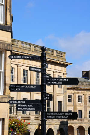 Buxton, UK - September 7, 2014 - Town centre signpost in front of the Buxton Crescent, Buxton, Derbyshire, England, UK, Western Europe.のeditorial素材
