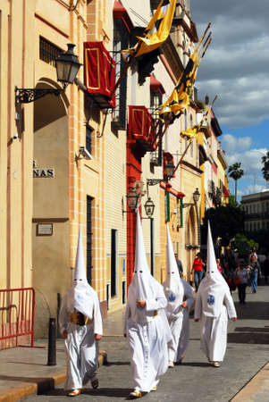 Seville, Spain - April 7, 2009 - Members of the Candelaria brotherhood walking along the street...