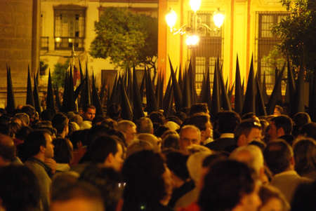 Seville, Spain - April 7, 2009 - Members of La Bofeta brotherhood walking through the crowds around...