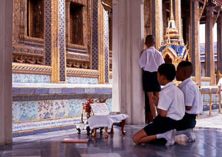 Boys praying at the Wat Phra Kaew Complex, Grand Palace, Bangkok, Thailandのeditorial素材