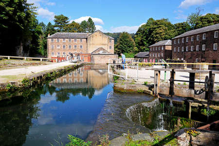 Cromford Mill (water powered cotton spinning mill) with a sluice mechanism in the foreground, Cromford, Derbyshire, England, UK, Western Europe.のeditorial素材