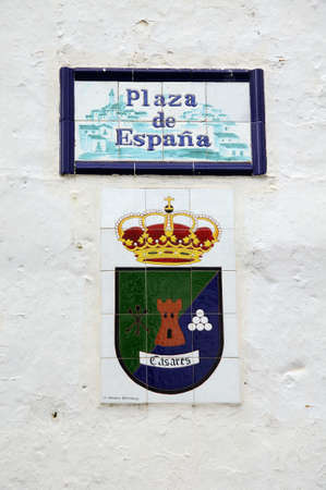 Plaza de Espana sign and town crest on a white wall, Casares, Cadiz Province, Costa del Sol, Malaga Province, Andalusia, Spain, Western Europe.のeditorial素材