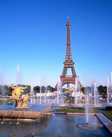View of the Eiffel Tower with fountains in the foreground and tourists sitting on the grass, Paris, France, Western Europe.のeditorial素材
