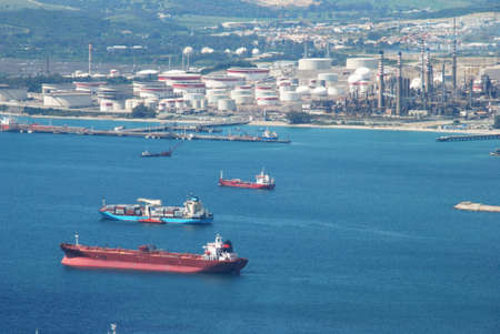 Elevated view of merchant ships in the bay with the Petrochemical oil refinery of Puente Mayorga along the Spanish coastline to the rear, Gibraltar, United Kingdom, Western Europe.のeditorial素材