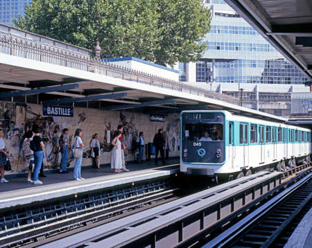 Metro train alongside the platform at Bastille railway station with passengers waiting, Paris, France, Western Europe.のeditorial素材
